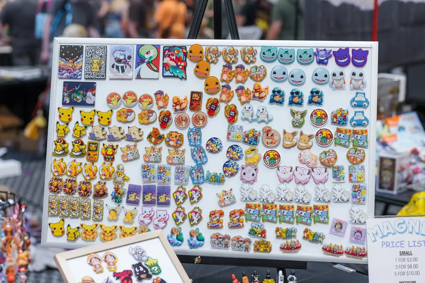 A vendor board filled edge to edge with colorful collectible pins at IZZISCON