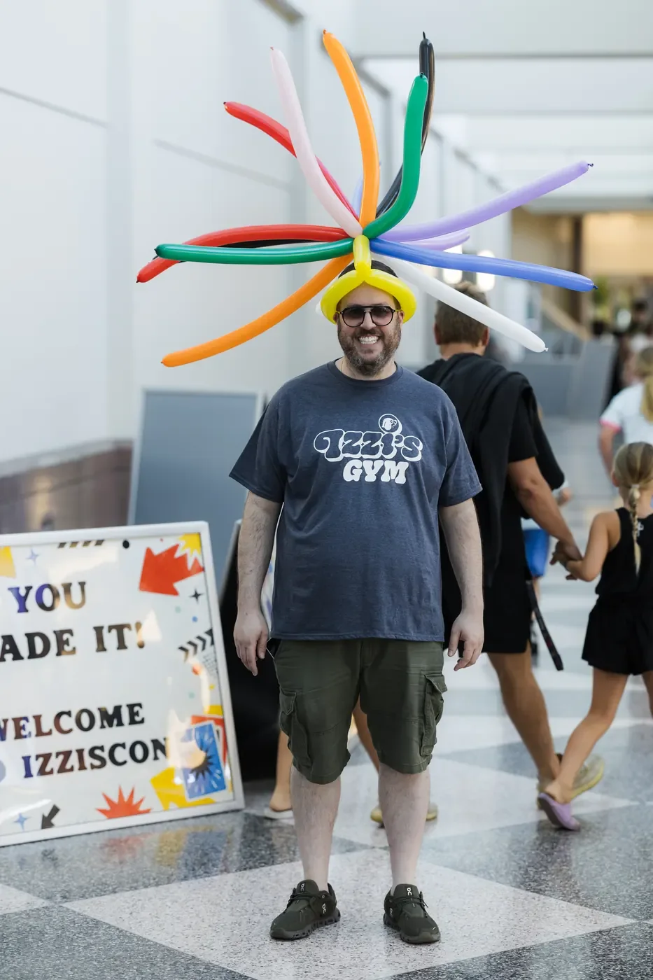 An IZZISCON attendee wearing an Izzi's Gym shirt and a balloon hat