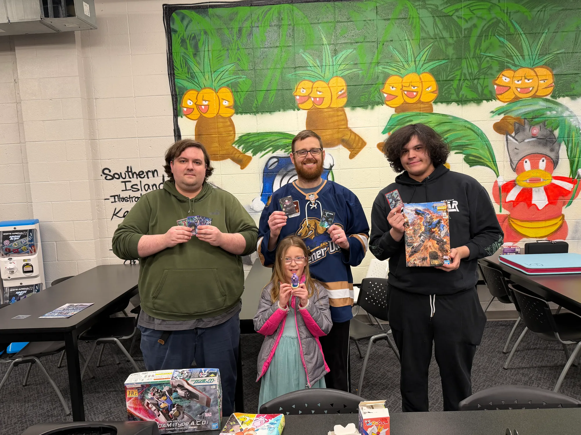 Gundam Club participants pose with trading cards and Gundam model kits